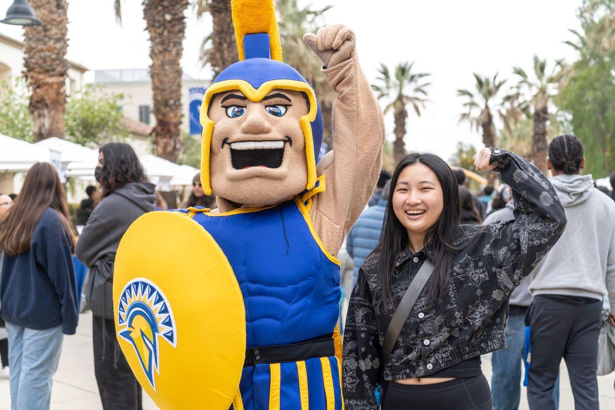 Student and Sammy with one armed raised in an empowered stance.