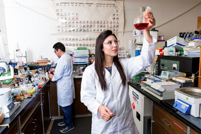 Two students in a science lab conducting work.